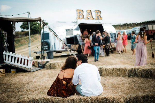 couple-sat-on-hay-bale-at-wedding-cornwall